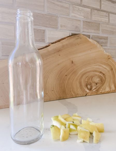clear glass bottle and cut up lemon peels