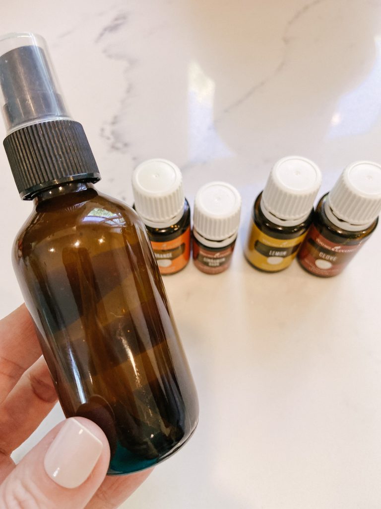 glass spray bottle with essential oil bottles on counter