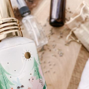 kid detangle spray in decorative glass bottle with clear and amber glass bottles on counter