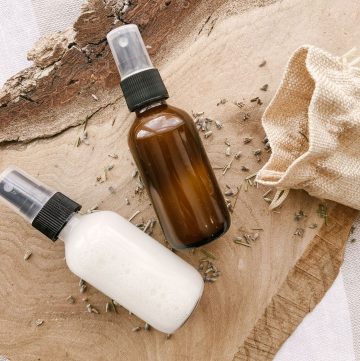 diy hair detangler spray in clear and amber glass bottle on wood slab