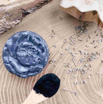 charcoal soap bar with activated charcoal powder on wooden spoon