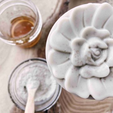 clay face wash with flower print, raw honey and bentonite clay powder on counter